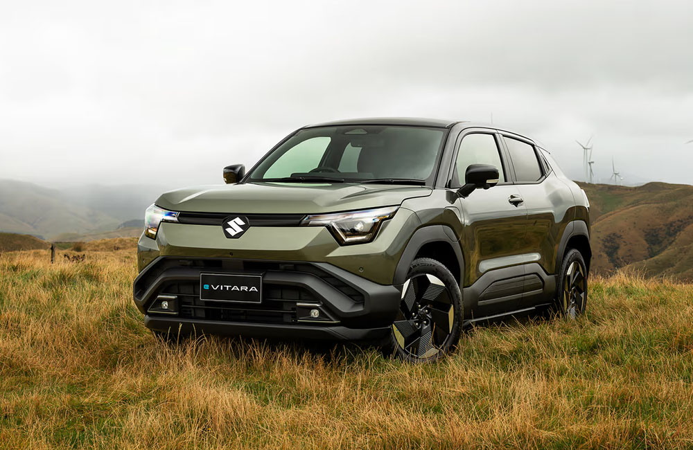 A Green electric SUV parked on a grassy hill