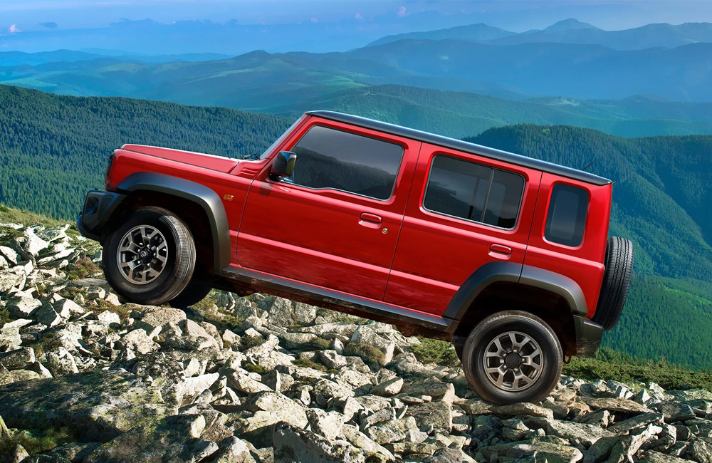 A red SUV driving over rocks
